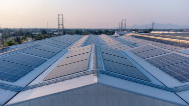 Geleceğin yeşil enerjisi ve sürdürülebilir elektrik kaynağı kavramı. Açık havada güneş panelleri çatılarda ya da İHA 'larla fabrikaların fotovoltaikleri üzerinde yoğunlaşıyor. Mavi tonlu güneş pili ızgaralı endüstriyel çatı.