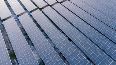 Geleceğin yeşil enerjisi ve sürdürülebilir elektrik kaynağı kavramı. Açık havada güneş panelleri çatılarda ya da İHA 'larla fabrikaların fotovoltaikleri üzerinde yoğunlaşıyor. Mavi tonlu güneş pili ızgaralı endüstriyel çatı.