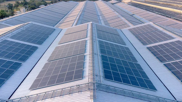 Geleceğin yeşil enerjisi ve sürdürülebilir elektrik kaynağı kavramı. Açık havada güneş panelleri çatılarda ya da İHA 'larla fabrikaların fotovoltaikleri üzerinde yoğunlaşıyor. Mavi tonlu güneş pili ızgaralı endüstriyel çatı.