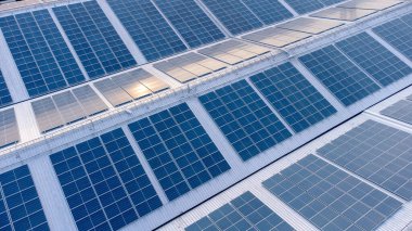 Eko çevresindeki fabrikanın güneş çatısı görüntüsü. Güneş pilleri güneş paneli yansıması yapıyor ve endüstriyel alanda mavi renge dönüşüyor. Enerji geri dönüşümü kavramı.