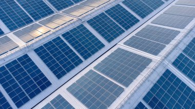 Eko çevresindeki fabrikanın güneş çatısı görüntüsü. Güneş pilleri güneş paneli yansıması yapıyor ve endüstriyel alanda mavi renge dönüşüyor. Enerji geri dönüşümü kavramı.