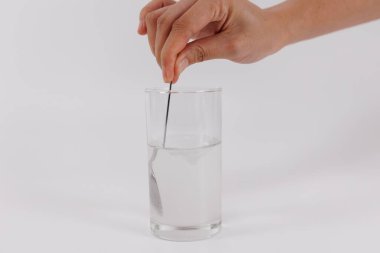 Bilimadamı el, bir bardak su üzerinde örnek testi yapıyor. Vitaminler, probiyotikler, ağrı kesiciler, ilaçlar ve diyet takviyeleri kontrol ediliyor. Hastalık önleme ve tedavi kavramı, sağlık hizmetleri.