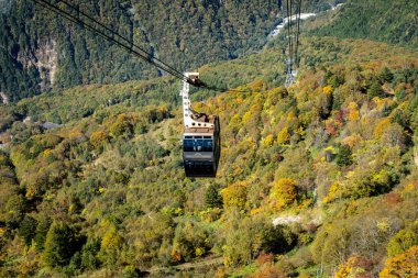 Ana turistik ilgi odağı Shin Hotaka 'nın sonbahar renklerinde bir teleferik ve turistlere hizmet veren bir halatla. Japon Alpleri, Shinhotaka halatı ve sonbahar yaprakları..