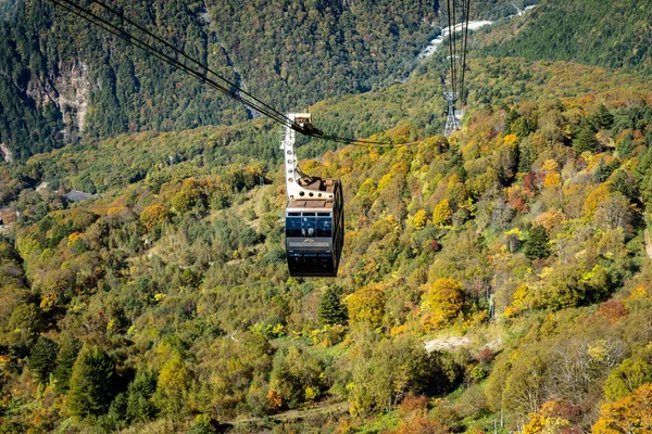 Ana turistik ilgi odağı Shin Hotaka 'nın sonbahar renklerinde bir teleferik ve turistlere hizmet veren bir halatla. Japon Alpleri, Shinhotaka halatı ve sonbahar yaprakları..