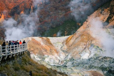 Shikotsu-Toya Ulusal Parkı, Hokkaido, Japonya - Kasım 2023: Kimliği belirsiz bir grup turist Sonbaharda güzel bir manzara ve cehennem vadisinde yükselen buhar veya Noboribetsu Jigokudani, Japonya
