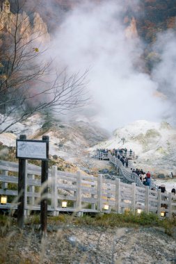 Shikotsu-Toya Ulusal Parkı, Hokkaido, Japonya - Kasım 2023: Kimliği belirsiz bir grup turist Sonbaharda güzel bir manzara ve cehennem vadisinde yükselen buhar veya Noboribetsu Jigokudani, Japonya