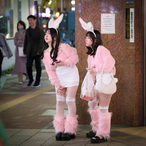 Sapporo, Japan - October 2023: Halloween night with a crowd of Japanese teenage wearing Halloween costumes and makeup walking the footpath in the Susukino cross area.