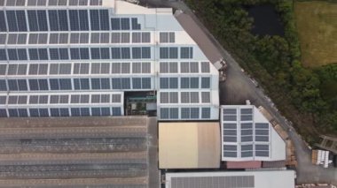 Endüstriyel santrallerin çatılarındaki güneş enerjisinin akşam saatlerinde 4K Aerial görüntüsü. Görüntü renk derecelendirme süreci yok.
