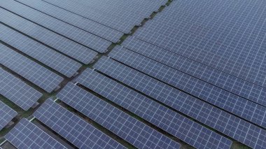 Bir binanın çatısına birden fazla güneş paneli yerleştirildi. Güneş panelleri düzenli sıra ve sütunlar halinde düzenlenir, her panel arasında net ayrılıklar bulunur. 