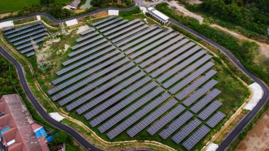 Bir binanın çatısına birden fazla güneş paneli yerleştirildi. Güneş panelleri düzenli sıra ve sütunlar halinde düzenlenir, her panel arasında net ayrılıklar bulunur. 