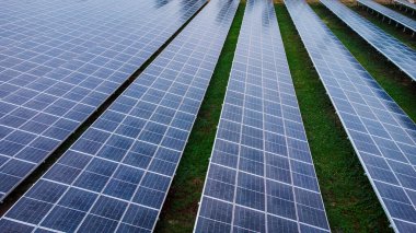 Bir binanın çatısına birden fazla güneş paneli yerleştirildi. Güneş panelleri düzenli sıra ve sütunlar halinde düzenlenir, her panel arasında net ayrılıklar bulunur. 
