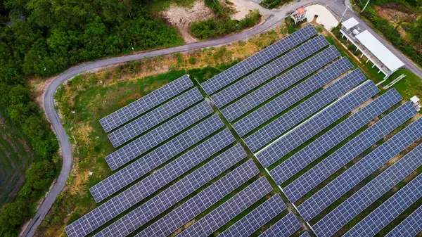 Bir binanın çatısına birden fazla güneş paneli yerleştirildi. Güneş panelleri düzenli sıra ve sütunlar halinde düzenlenir, her panel arasında net ayrılıklar bulunur. 