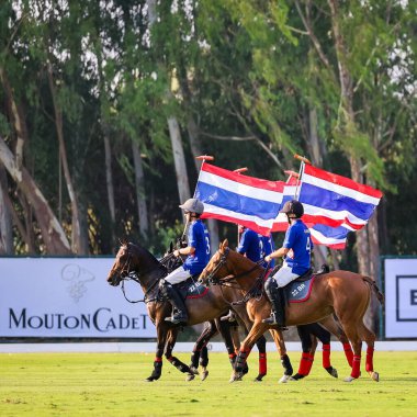 Phattaya, Tayland - 25 Ocak 2025: Bir polo maçı sırasında, Tayland polo kulübündeki çimenli bir sahada at süren beş oyuncunun yer aldığı an. 