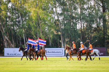 Phattaya, Tayland - 25 Ocak 2025: Bir polo maçı sırasında, Tayland polo kulübündeki çimenli bir sahada at süren beş oyuncunun yer aldığı an. 