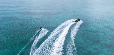 Okinawa sahilinin atmosferinde kristal berrak su, görünür kayalar ve kıyıya vuran dalgalar vardır..