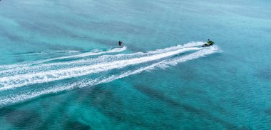 Okinawa sahilinin atmosferinde kristal berrak su, görünür kayalar ve kıyıya vuran dalgalar vardır..