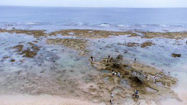 Okinawa 'da deniz yüzeyi temiz su ve insansız hava aracının öfke bakışından kayayla kaplı..