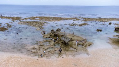 Okinawa 'da deniz yüzeyi temiz su ve insansız hava aracının öfke bakışından kayayla kaplı..