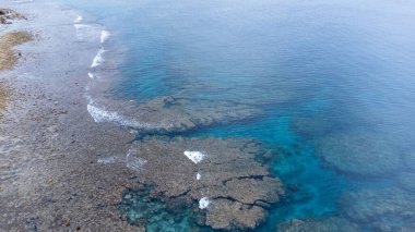 Okinawa 'da deniz yüzeyi temiz su ve insansız hava aracının öfke bakışından kayayla kaplı..