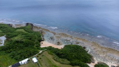 Okinawa 'da deniz yüzeyi temiz su ve insansız hava aracının öfke bakışından kayayla kaplı..