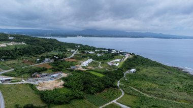 Okinawa, Japonya - Temmuz 2024: Kouri Adası 'nın uzun köprüsü ve açık gökyüzü ve deniz suyuna sahip insansız hava aracı tarafından yüksek görüş alanından kumsal.
