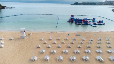 Okinawa 'nın sakin deniz manzaraları kristal berrak suları, açıktaki kayalık oluşumlar ve kıyıya vuran nazik dalgalar.