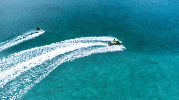 Okinawa sahilinin atmosferinde kristal berrak su, görünür kayalar ve kıyıya vuran dalgalar vardır..