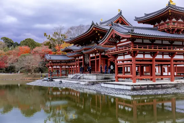 Kyoto, Japonya - Aralık 2024: Byodoin Tapınağı, UNESCO Dünya Mirasları Alanı, Uji, Kyoto. Resim, simetrik mimarisiyle ikonik Phoenix Salonu 'nu sergiliyor. Huzurlu gölete güzel yansıyor..