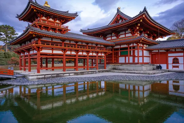 Kyoto, Japonya - Aralık 2024: Byodoin Tapınağı, UNESCO Dünya Mirasları Alanı, Uji, Kyoto. Resim, simetrik mimarisiyle ikonik Phoenix Salonu 'nu sergiliyor. Huzurlu gölete güzel yansıyor..