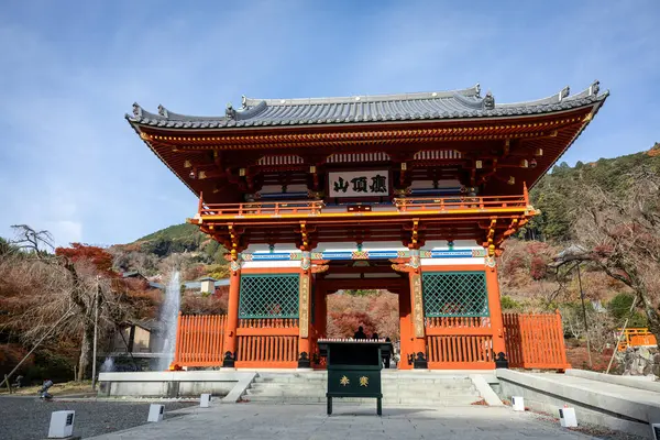 Osaka, Japonya - Aralık 2024: Minoh 'taki Katsuo-ji Tapınağı' nın en yoğun sonbahar dönemi manzarası. Canlı kırmızı ve turuncu akçaağaç yapraklarıyla güzelce çerçevelenmiş, Japon sonbaharının sakin atmosferini yansıtıyor..