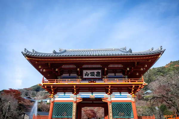 Osaka, Japonya - Aralık 2024: Minoh 'taki Katsuo-ji Tapınağı' nın en yoğun sonbahar dönemi manzarası. Canlı kırmızı ve turuncu akçaağaç yapraklarıyla güzelce çerçevelenmiş, Japon sonbaharının sakin atmosferini yansıtıyor..