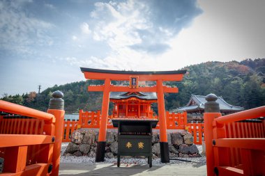 Osaka, Japonya - Aralık 2024: Minoh 'taki Katsuo-ji Tapınağı' nın en yoğun sonbahar dönemi manzarası. Canlı kırmızı ve turuncu akçaağaç yapraklarıyla güzelce çerçevelenmiş, Japon sonbaharının sakin atmosferini yansıtıyor..