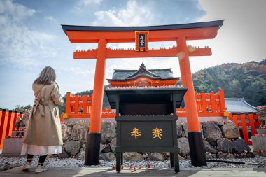 Osaka, Japonya - Aralık 2024: Minoh 'taki Katsuo-ji Tapınağı' nın en yoğun sonbahar dönemi manzarası. Canlı kırmızı ve turuncu akçaağaç yapraklarıyla güzelce çerçevelenmiş, Japon sonbaharının sakin atmosferini yansıtıyor..