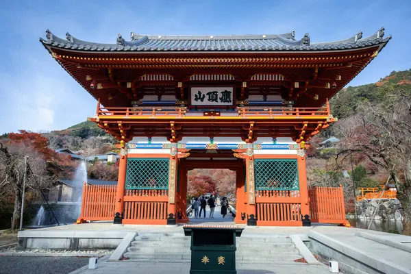 Osaka, Japonya - Aralık 2024: Minoh 'taki Katsuo-ji Tapınağı' nın en yoğun sonbahar dönemi manzarası. Canlı kırmızı ve turuncu akçaağaç yapraklarıyla güzelce çerçevelenmiş, Japon sonbaharının sakin atmosferini yansıtıyor..