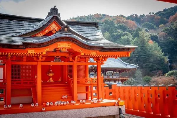 Osaka, Japonya - Aralık 2024: Minoh 'taki Katsuo-ji Tapınağı' nın en yoğun sonbahar dönemi manzarası. Canlı kırmızı ve turuncu akçaağaç yapraklarıyla güzelce çerçevelenmiş, Japon sonbaharının sakin atmosferini yansıtıyor..