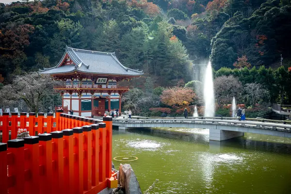 Osaka, Japonya - Aralık 2024: Minoh 'taki Katsuo-ji Tapınağı' nın en yoğun sonbahar dönemi manzarası. Canlı kırmızı ve turuncu akçaağaç yapraklarıyla güzelce çerçevelenmiş, Japon sonbaharının sakin atmosferini yansıtıyor..