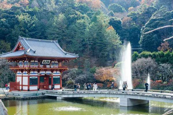 Osaka, Japonya - Aralık 2024: Minoh 'taki Katsuo-ji Tapınağı' nın en yoğun sonbahar dönemi manzarası. Canlı kırmızı ve turuncu akçaağaç yapraklarıyla güzelce çerçevelenmiş, Japon sonbaharının sakin atmosferini yansıtıyor..