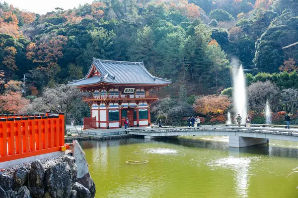 Osaka, Japonya - Aralık 2024: Minoh 'taki Katsuo-ji Tapınağı' nın en yoğun sonbahar dönemi manzarası. Canlı kırmızı ve turuncu akçaağaç yapraklarıyla güzelce çerçevelenmiş, Japon sonbaharının sakin atmosferini yansıtıyor..