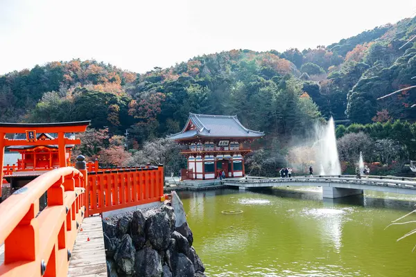 Osaka, Japonya - Aralık 2024: Minoh 'taki Katsuo-ji Tapınağı' nın en yoğun sonbahar dönemi manzarası. Canlı kırmızı ve turuncu akçaağaç yapraklarıyla güzelce çerçevelenmiş, Japon sonbaharının sakin atmosferini yansıtıyor..