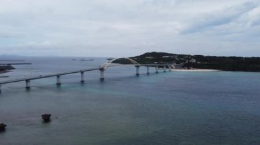 4K Okinawa 'nın sakin deniz manzarası kristal berrak suları, açıkta kayalık oluşumlar ve kıyıya vuran nazik dalgalar sergiliyor.