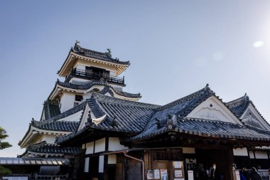 Kochi Şehri, Shikoku, Japonya - Aralık 2024: Kochi Kalesi canlı sonbahar yapraklarıyla çevrili iyi korunmuş bir Japon kalesidir. Ahşap yapının geleneksel kalesi kırmızı akçaağaç ve altın ginkgo ağaçları arasında zarif duruyor..