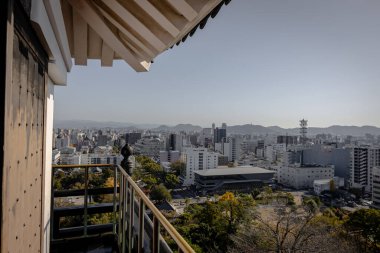 Kochi Şehri, Shikoku, Japonya - Aralık 2024: Kochi Kalesi canlı sonbahar yapraklarıyla çevrili iyi korunmuş bir Japon kalesidir. Ahşap yapının geleneksel kalesi kırmızı akçaağaç ve altın ginkgo ağaçları arasında zarif duruyor..