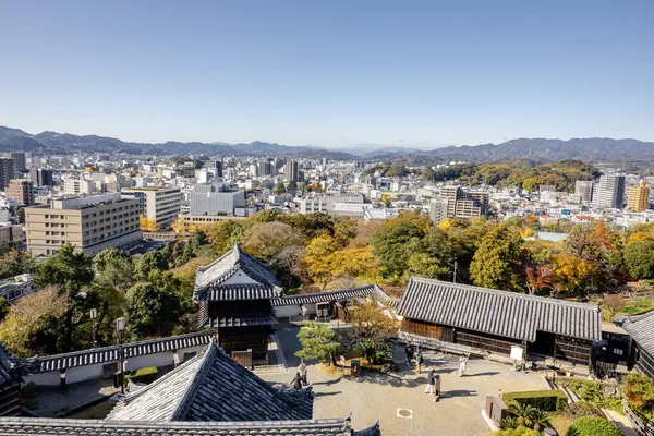 Kochi Şehri, Shikoku, Japonya - Aralık 2024: Kochi Kalesi canlı sonbahar yapraklarıyla çevrili iyi korunmuş bir Japon kalesidir. Ahşap yapının geleneksel kalesi kırmızı akçaağaç ve altın ginkgo ağaçları arasında zarif duruyor..