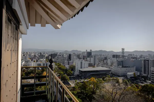 Kochi Şehri, Shikoku, Japonya - Aralık 2024: Kochi Kalesi canlı sonbahar yapraklarıyla çevrili iyi korunmuş bir Japon kalesidir. Ahşap yapının geleneksel kalesi kırmızı akçaağaç ve altın ginkgo ağaçları arasında zarif duruyor..