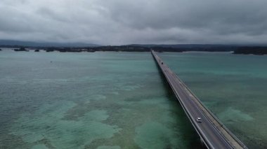 4K, Kouri Adası 'nın Long Köprüsü üzerindeki yola ve açık gökyüzü ve deniz suyuna sahip insansız hava aracının yüksek görüş alanından sahile odaklanıyor..