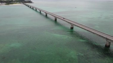 4K, Kouri Adası 'nın Long Köprüsü üzerindeki yola ve açık gökyüzü ve deniz suyuna sahip insansız hava aracının yüksek görüş alanından sahile odaklanıyor..