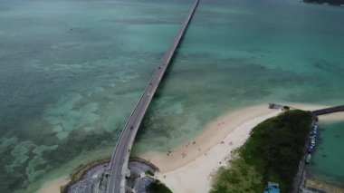 4K, Kouri Adası 'nın Long Köprüsü üzerindeki yola ve açık gökyüzü ve deniz suyuna sahip insansız hava aracının yüksek görüş alanından sahile odaklanıyor..