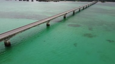 4K, Kouri Adası 'nın Long Köprüsü üzerindeki yola ve açık gökyüzü ve deniz suyuna sahip insansız hava aracının yüksek görüş alanından sahile odaklanıyor..