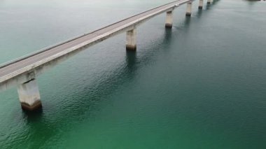 4K, Kouri Adası 'nın Long Köprüsü üzerindeki yola ve açık gökyüzü ve deniz suyuna sahip insansız hava aracının yüksek görüş alanından sahile odaklanıyor..