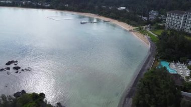 4K Okinawa 'nın sakin deniz manzarası üzerinde kristal berrak sular, açıkta kayalık oluşumlar ve kıyıya doğru hafif dalgalar.